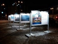 аллея уличных информационных стендов со стеклом в вечерней подсветке